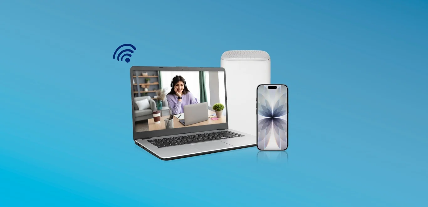 A girl smiles while wearing white headphones sitting at the kitchen table inside of a laptop screen next to a white wifi modem behind a white iPhone 16e device.